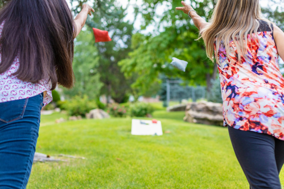 Family playing cornhole in yard