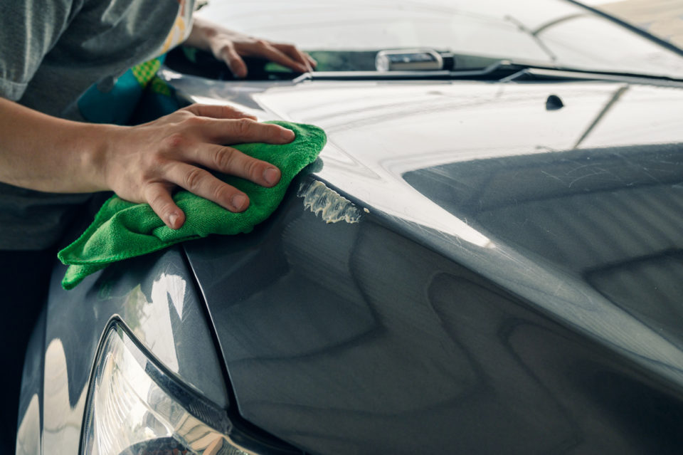 Man waxes car to protect it from the sun