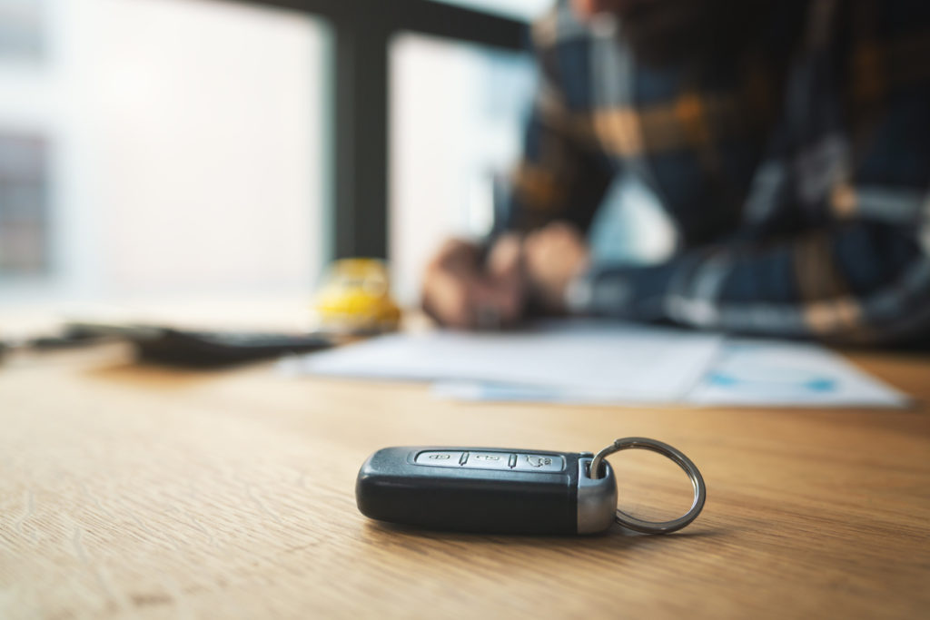 Man signing car insurance document or lease paper