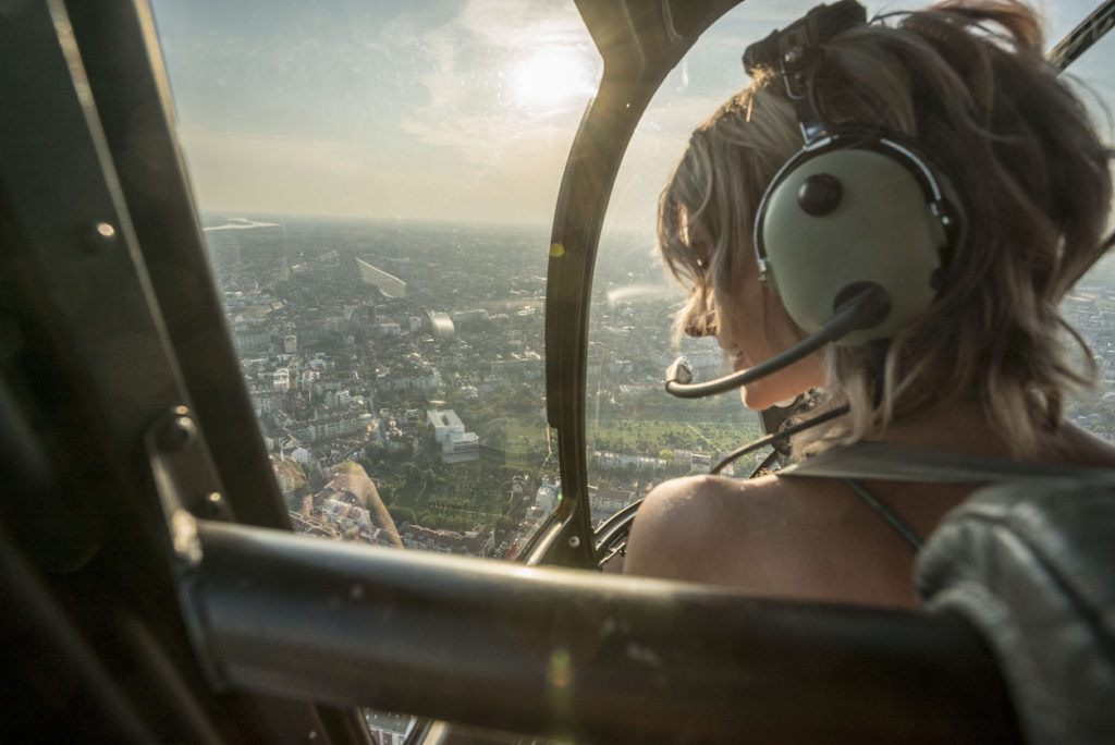 blonde woman enjoying helicopter flight.